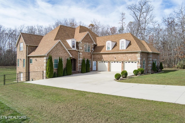 traditional-style home featuring fence, roof with shingles, a front yard, brick siding, and driveway