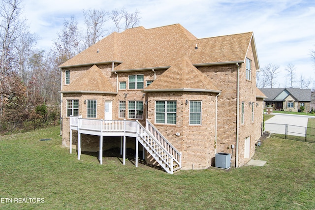 rear view of house featuring central air condition unit, a yard, and a deck