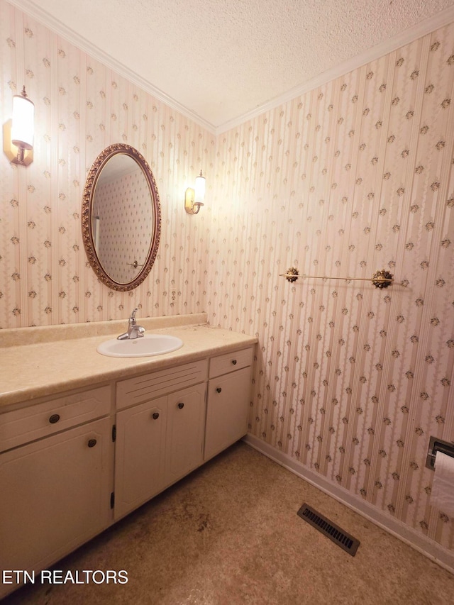 bathroom with vanity, a textured ceiling, and crown molding