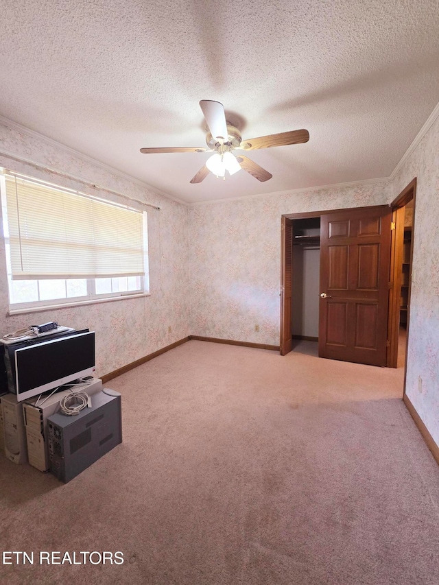 interior space with ceiling fan, a textured ceiling, and carpet