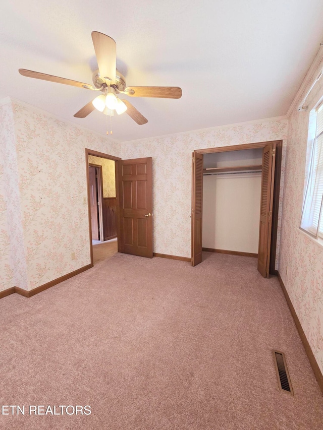 unfurnished bedroom with a closet, carpet, and ceiling fan