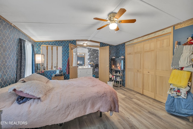 bedroom with a closet, wood-type flooring, vaulted ceiling, and ceiling fan