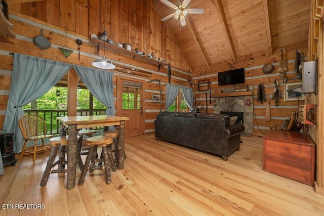 dining space featuring beam ceiling, high vaulted ceiling, wood ceiling, light hardwood / wood-style floors, and ceiling fan