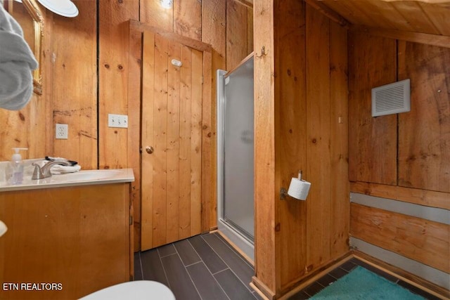 bathroom featuring wood walls, an enclosed shower, vanity, and vaulted ceiling