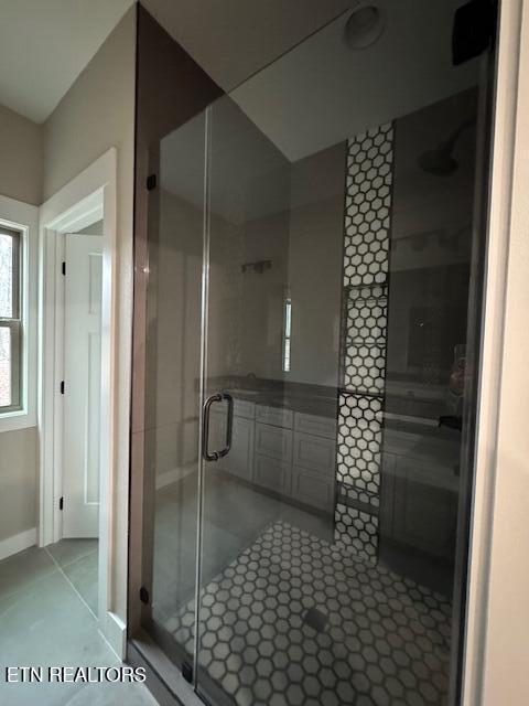 full bathroom featuring tile patterned flooring and a shower stall