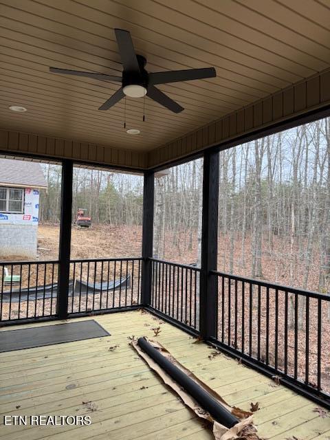 unfurnished sunroom with ceiling fan and wooden ceiling