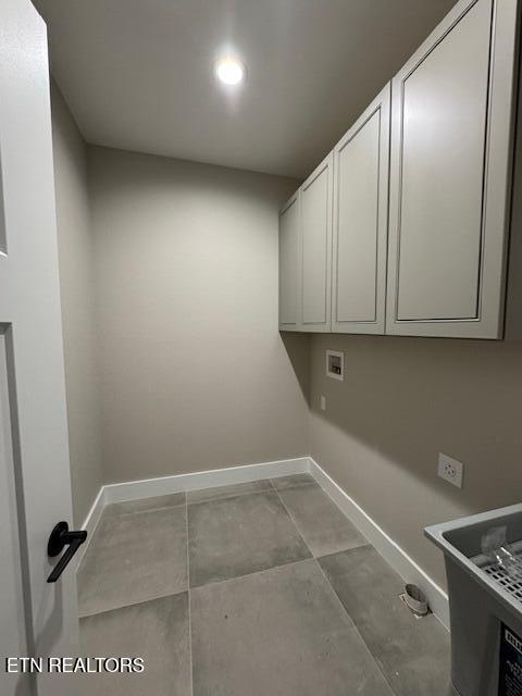 washroom featuring hookup for a washing machine, cabinet space, and baseboards