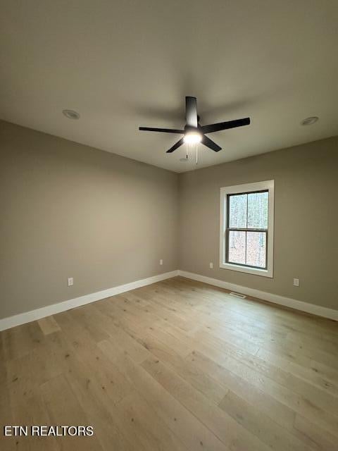 empty room featuring visible vents, light wood-style flooring, and baseboards