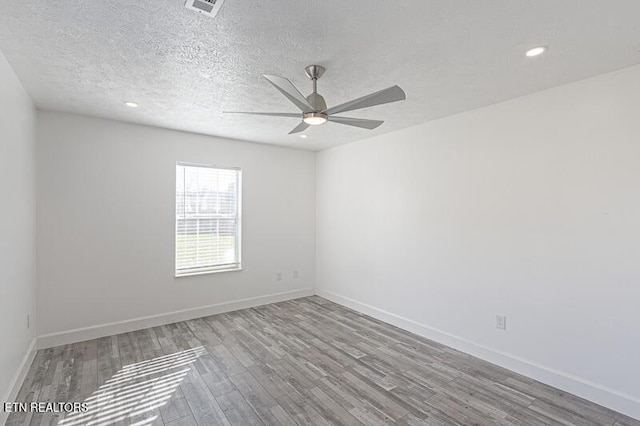 unfurnished room featuring a textured ceiling and light hardwood / wood-style floors