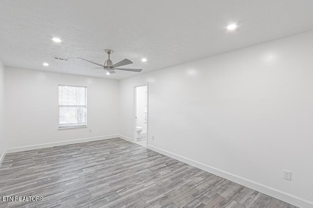 empty room featuring ceiling fan, light hardwood / wood-style flooring, and a textured ceiling