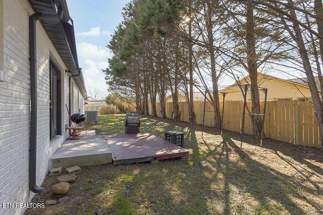 view of yard with central air condition unit and a wooden deck