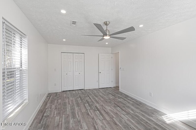 unfurnished bedroom with a closet, ceiling fan, light hardwood / wood-style flooring, and a textured ceiling