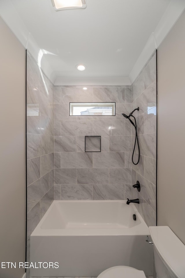 bathroom featuring tiled shower / bath and toilet