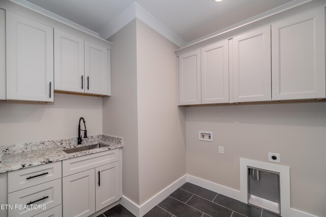 laundry room featuring sink, hookup for a washing machine, cabinets, dark tile patterned floors, and hookup for an electric dryer