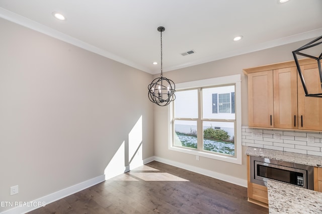 unfurnished living room featuring an inviting chandelier, dark hardwood / wood-style floors, and ornamental molding