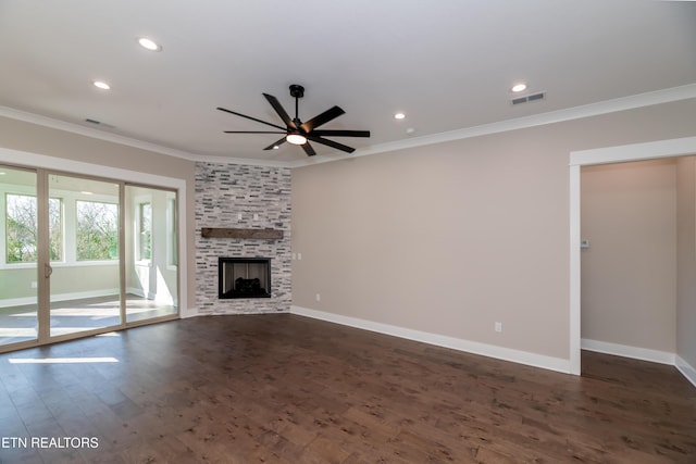 unfurnished living room with ornamental molding, a stone fireplace, dark wood-type flooring, and ceiling fan