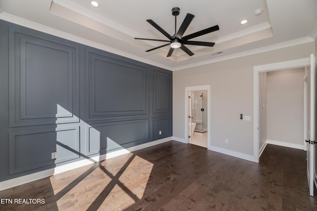 interior space featuring ceiling fan, ornamental molding, dark wood-type flooring, and a raised ceiling