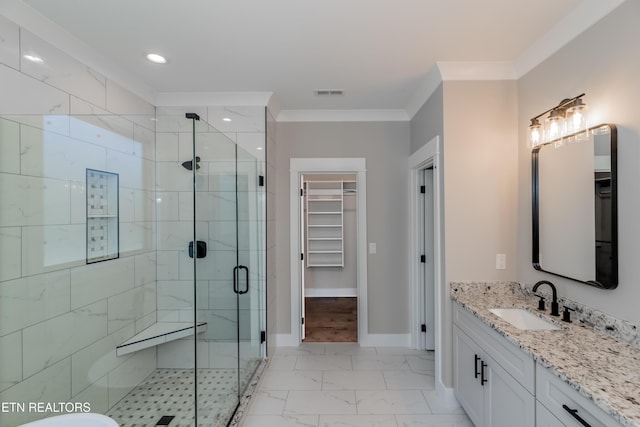 bathroom with a shower with shower door, vanity, and crown molding