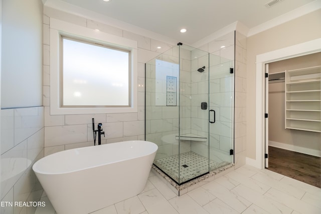 bathroom with separate shower and tub, tile walls, and crown molding