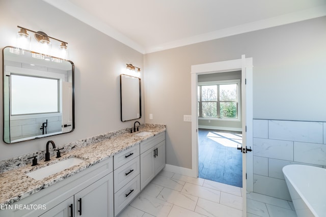 bathroom featuring tile walls, ornamental molding, vanity, and a tub to relax in