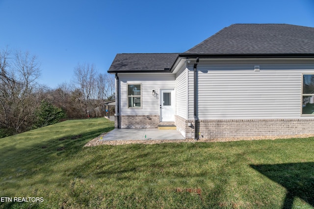 view of side of home with a yard and a patio area