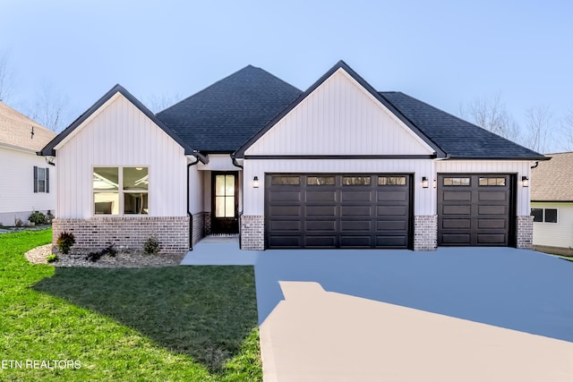 modern farmhouse featuring a front yard and a garage