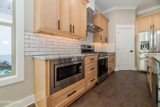 kitchen with light stone counters, wall chimney range hood, stainless steel appliances, light brown cabinets, and ornamental molding