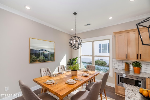 dining space featuring crown molding, dark hardwood / wood-style flooring, and a notable chandelier