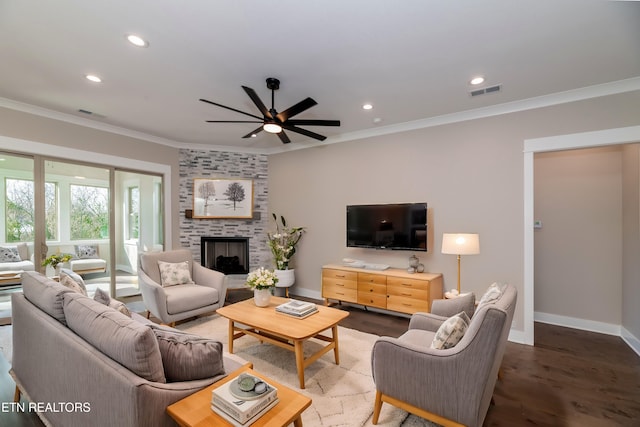 living room featuring ceiling fan, crown molding, dark hardwood / wood-style floors, and a fireplace