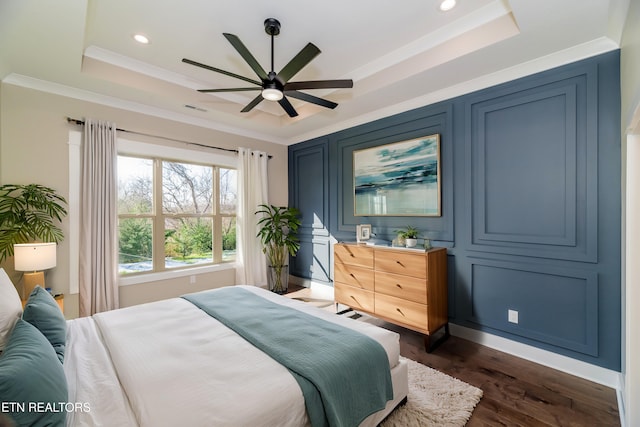 bedroom featuring ceiling fan, crown molding, dark hardwood / wood-style flooring, and a raised ceiling