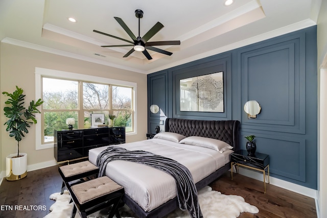 bedroom featuring ornamental molding, dark hardwood / wood-style floors, ceiling fan, and a raised ceiling