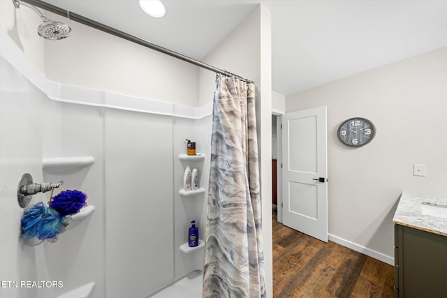 bathroom featuring hardwood / wood-style floors, walk in shower, and vanity