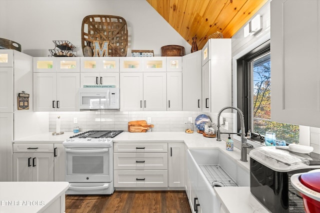 kitchen featuring dark hardwood / wood-style flooring, lofted ceiling, white cabinets, sink, and white appliances