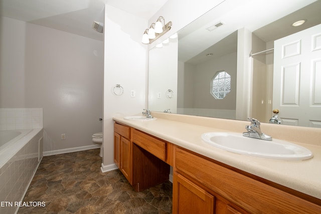 bathroom featuring vanity, tiled tub, and toilet