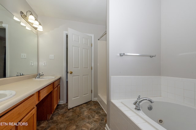 bathroom with tiled bath and vanity