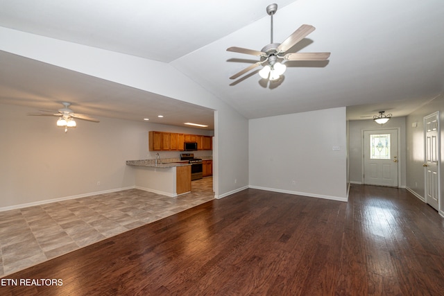 unfurnished living room featuring ceiling fan, wood-type flooring, sink, and lofted ceiling