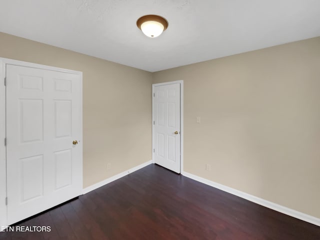 unfurnished room with dark hardwood / wood-style flooring