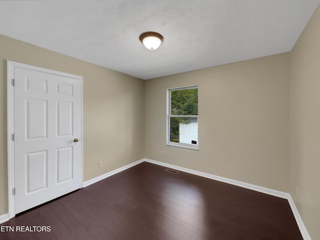 unfurnished room with dark hardwood / wood-style floors