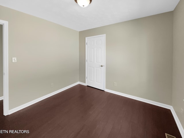 spare room featuring dark wood-type flooring