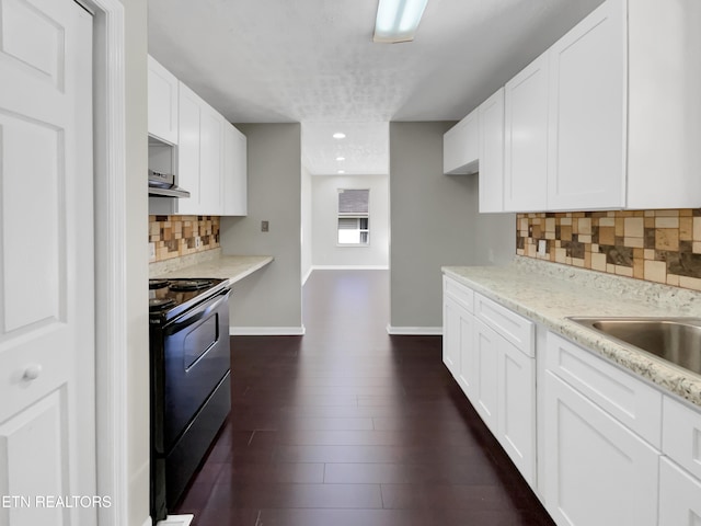 kitchen featuring dark hardwood / wood-style floors, white cabinets, black range with electric stovetop, decorative backsplash, and exhaust hood