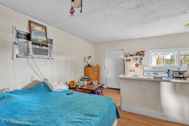 208 Collins St, Loudon, TN 37774 - bedroom with white refrigerator, a textured ceiling, and light hardwood / wood-style flooring