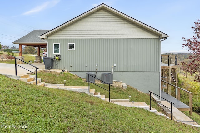 view of property exterior featuring a lawn and cooling unit