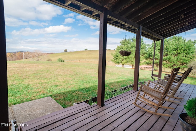 deck with a yard and a rural view