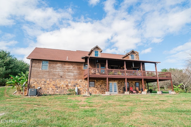 back of property with central AC unit and a lawn