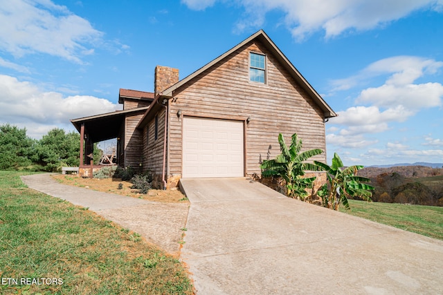 view of side of home featuring a garage and a yard