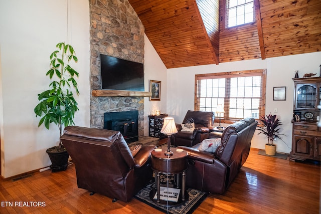 living room with high vaulted ceiling, wood ceiling, hardwood / wood-style flooring, and a stone fireplace