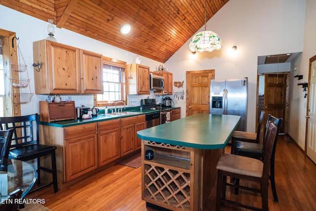 kitchen with appliances with stainless steel finishes, high vaulted ceiling, wood ceiling, sink, and light hardwood / wood-style flooring