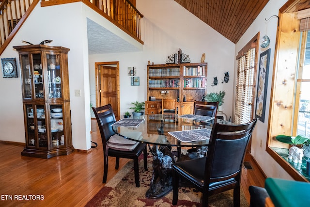 dining area with wood-type flooring, vaulted ceiling, and wooden ceiling