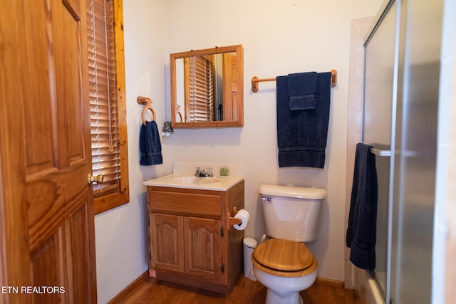 bathroom with walk in shower, wood-type flooring, vanity, and toilet