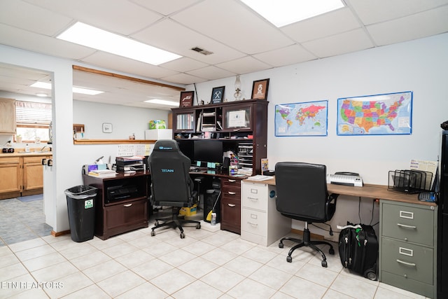 home office featuring a drop ceiling and light tile patterned floors